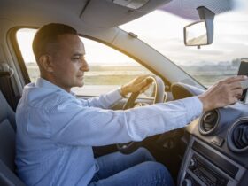 driver is checking something on his mobile phone on the dashboard